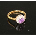 A modern 18ct gold, amethyst and diamond set circular cluster ring, size I, gross weight 3.2