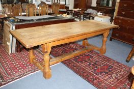 A large 17th century style pine refectory table, on turned legs with H stretcher, W.243cm D.92cm H.