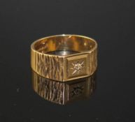 A modern 9ct gold and diamond chip set signet ring, with textured shoulders, size R/S, gross 3.9