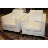 A pair of modern Italian cream leather upholstered armchairs, with ebonised feet, W.80cm D.90cm H.