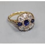 A Victorian style 18ct, three stone sapphire and six stone diamond set circular cluster ring, with