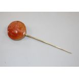 An early 20th century yellow metal and carnelian cameo set stick pin, carved with the head of a lady