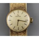 A lady's 1960's? 9ct gold Omega manual wind wristwatch, on integral textured 9ct gold Omega