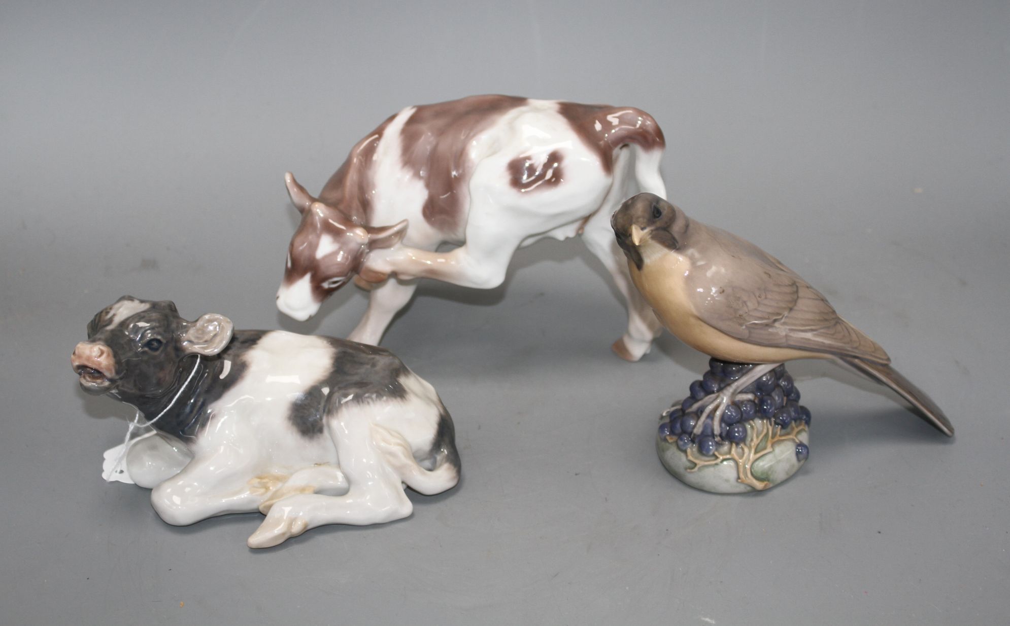 Two Royal Copenhagen figures of a bird, model 1235 and a calf, model 1072 and a Bing & Grondahl