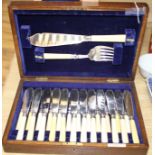 A cased set of twelve pairs of plated fish knives and forks with servers, silver banded ivorine