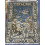 A pair of Persian blue ground small mats, decorated with animals amongst trees and flowers, and