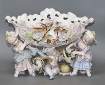 An early 20th century German porcelain centrepiece, with floral encrusted bowl supported by three