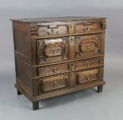 A late 17th century oak chest, of four long drawers with geometric moulded decoration, on stile