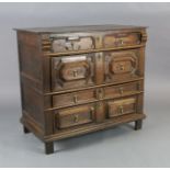 A late 17th century oak chest, of four long drawers with geometric moulded decoration, on stile