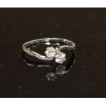 An 18ct and Plat, two stone diamond crossover ring, size P/Q, gross weight 2.5 grams. Condition: