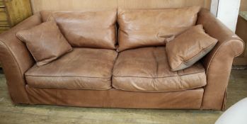 A Heals brown leather sofa, W.220cm D.94cm H.72cm Condition: The leather has marks and scratches due