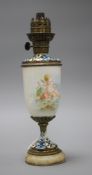 An early 20th century French champleve enamel bronze and ceramic lamp base, painted with a cherub,