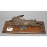 An Austrian cold painted door knocker modelled as a running hare, with oak mount, overall length