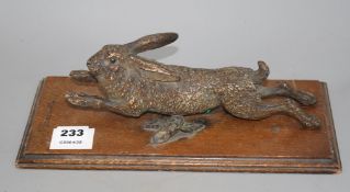 An Austrian cold painted door knocker modelled as a running hare, with oak mount, overall length