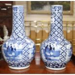 A pair of 19th century Chinese blue and white vases, decorated with panels of figures in gardens,