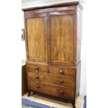 A Regency mahogany linen press with two doors enclosing five slides, two short drawers and two