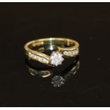 A modern 18ct gold and single stone diamond ring, with diamond set shoulders, size L/M, gross weight