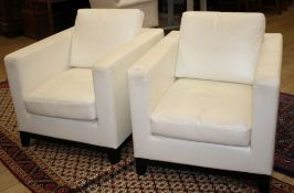 A pair of modern Italian cream leather upholstered armchairs, with ebonised feet, W.80cm D.90cm H.