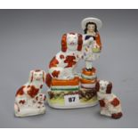 A Victorian Staffordshire girl and spaniel group, height 19cm and two smaller Staffordshire dogs,