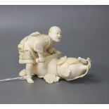 A Japanese Meiji period ivory okimono carved with a man carving a giant gourd, signed, length