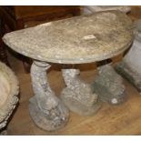 A reconstituted stone demi lune garden seat, on dolphin supports, W.90cm D.45cm H.80cm Condition: