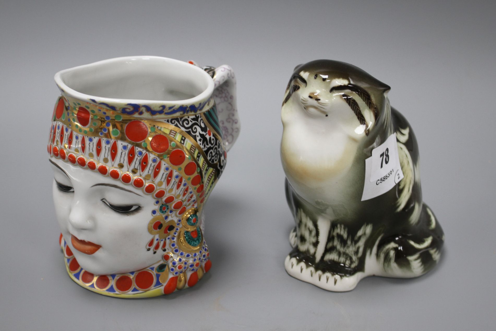 A Russian ceramic figure of a seated cat, height 15cm, and a character jug depicting a woman's