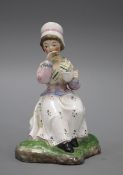 A 19th century Staffordshire figure of a seated young lady taking tea, height 13cm Condition: Good