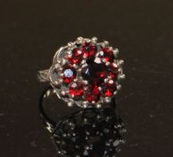 A 14k yellow metal and nine stone garnet cluster dress ring, size O, gross weight 5.6 grams.