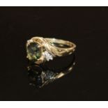 A modern 9ct gold, olive green paste and diamond set dress ring, size S, gross weight 3.2 grams.