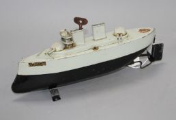 A Sutcliffe Valiant enamelled metal model battleship, clockwork with key and stand, unboxed