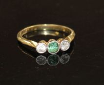 An 18ct and plat, green tourmaline and diamond set three stone ring, size M, gross weight 2.3 grams.