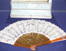 A Maison Patte-Hannot boxed lacework fan, with simulated amber sticks, inset with a rose diamond set