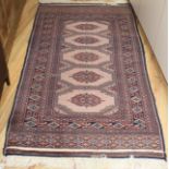 A Bokhara peach ground rug, 175 x 93cm Condition: Worn down to the pile in several streaks running