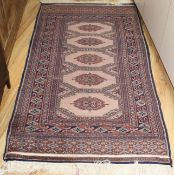 A Bokhara peach ground rug, 175 x 93cm Condition: Worn down to the pile in several streaks running