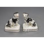 A pair of Staffordshire porcelain figures of seated King Charles spaniels, c.1830-50, stained