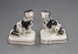 A pair of Staffordshire porcelain figures of seated King Charles spaniels, c.1830-50, stained