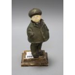An Art Deco silver overlaid bronze and ivory figure of a boy wearing winter coat and cap, overall