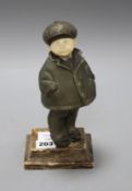 An Art Deco silver overlaid bronze and ivory figure of a boy wearing winter coat and cap, overall