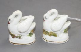 A pair of Staffordshire porcelain models of swans, c.1830-50, typical small manufacturing
