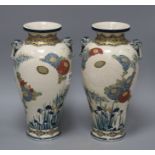 A pair of Satsuma vases, decorated with chrysanthemums, irises and storks, with beast head lug