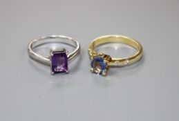 A modern yellow metal and single stone oval cut Ceylon? sapphire ring with diamond set shoulders,