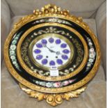 An ornate floral painted circular wall clock