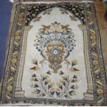 A Tabriz cream ground prayer rug, with central urn of flowers flanked by birds and further floral