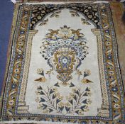 A Tabriz cream ground prayer rug, with central urn of flowers flanked by birds and further floral