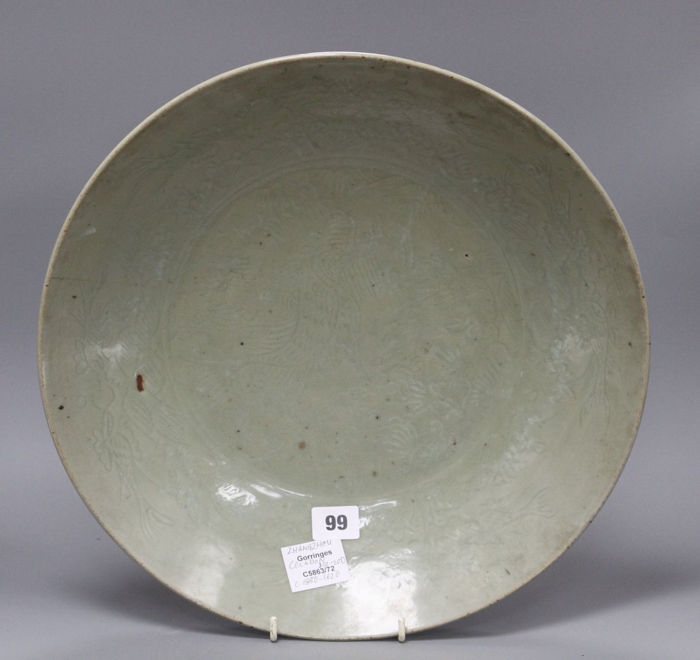 A Chinese Ming celadon dish, Zhangzhou kilns, c.1580-1620, incised with fish and water plants,