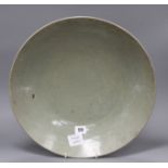 A Chinese Ming celadon dish, Zhangzhou kilns, c.1580-1620, incised with fish and water plants,