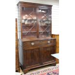 A George III style mahogany bookcase, with two astragal glazed doors over a fall front drawer and