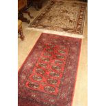 A Meshed machined wool rug, 190 x 126cm and a Bokhara machined rug, 170 x 83cm Condition: Both a
