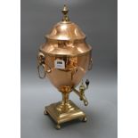 A Regency brass mounted copper tea urn, with ram's mask ring handles, height 51cm Condition: Fair