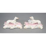 A pair of Staffordshire porcelain figures of recumbent greyhounds, c.1835-50, each on pink and